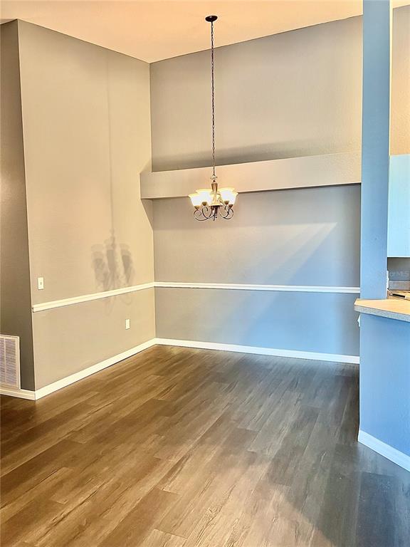 A dining area features light gray walls, a chair rail, wood-look flooring, and a chandelier — 3361 S KIRKMAN ROAD UNIT 821, ORLANDO, FL