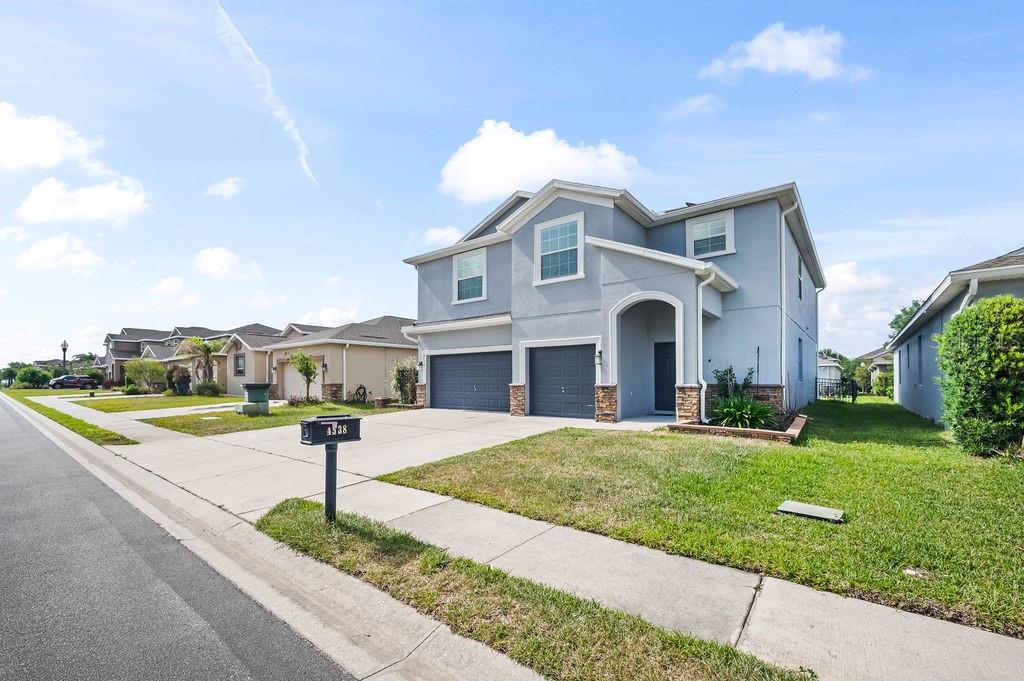 A two-story suburban house with a gray exterior, a two-car garage, and a front lawn — 4538 CORTLAND DRIVE, DAVENPORT, FL