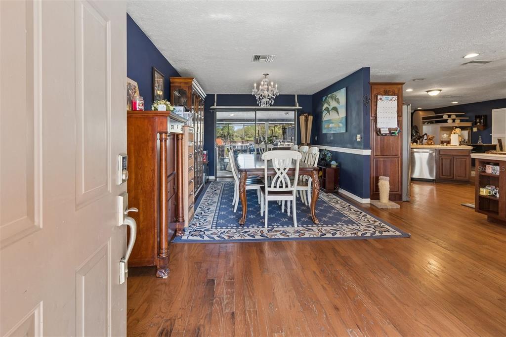 A view from an entryway into a dining room with hardwood floors and blue walls — 5059 BERNADETTE DRIVE, ZEPHYRHILLS, FL