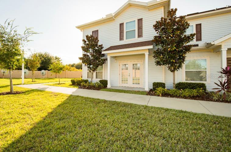 A two-story house with light blue siding, a covered entryway, and a concrete walkway — 3200 CUPID PLACE, KISSIMMEE, FL