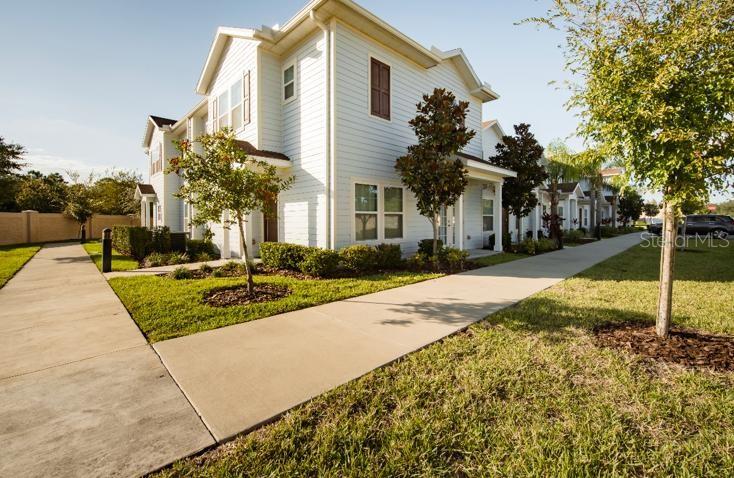 A two-story light blue house with a sidewalk leading to the front entrance — 3200 CUPID PLACE, KISSIMMEE, FL
