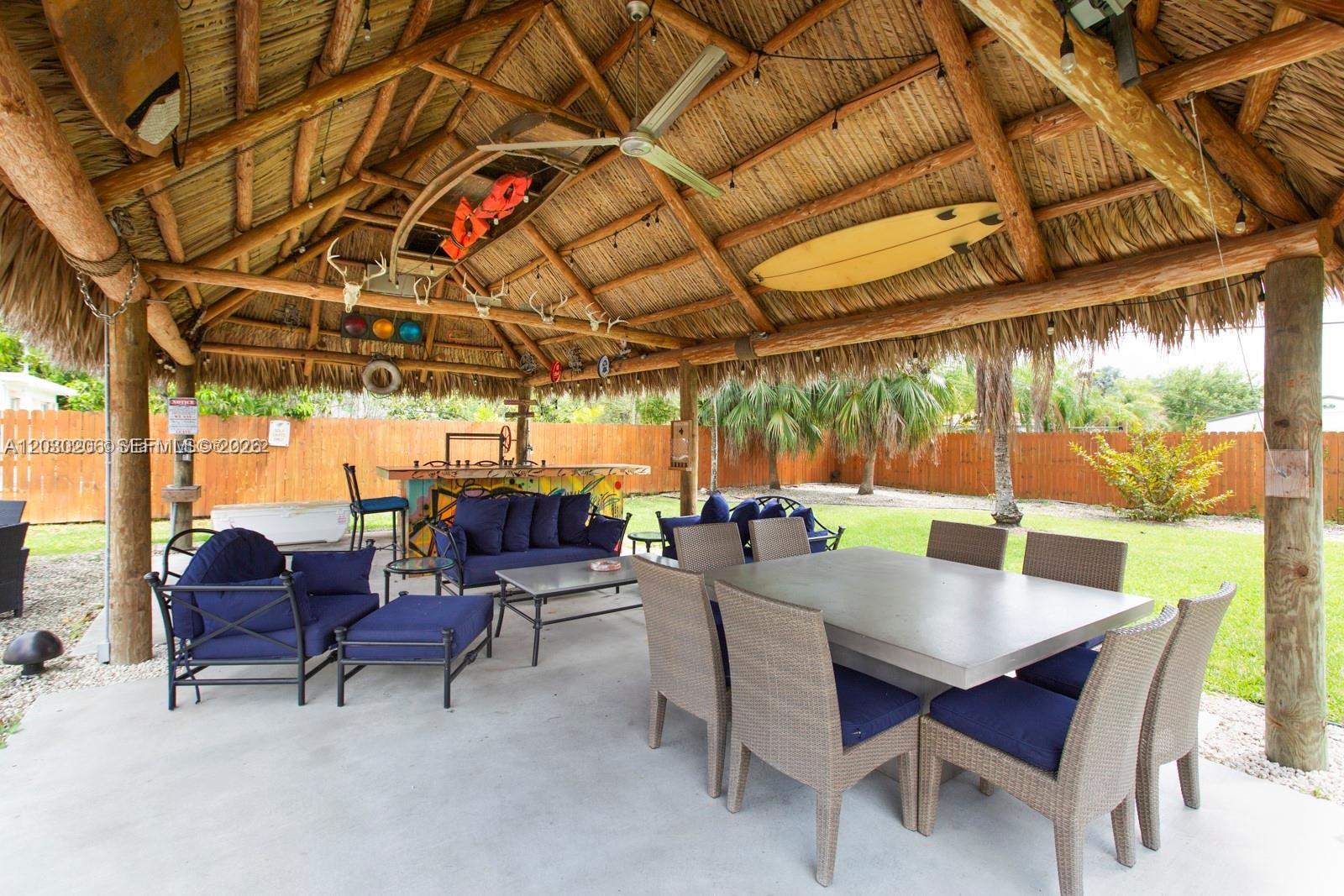 An outdoor tiki hut features a dining area, lounge seating, and a bar on a patio — 6530 SW 43rd St, Miami FL 33155, MIAMI, FL