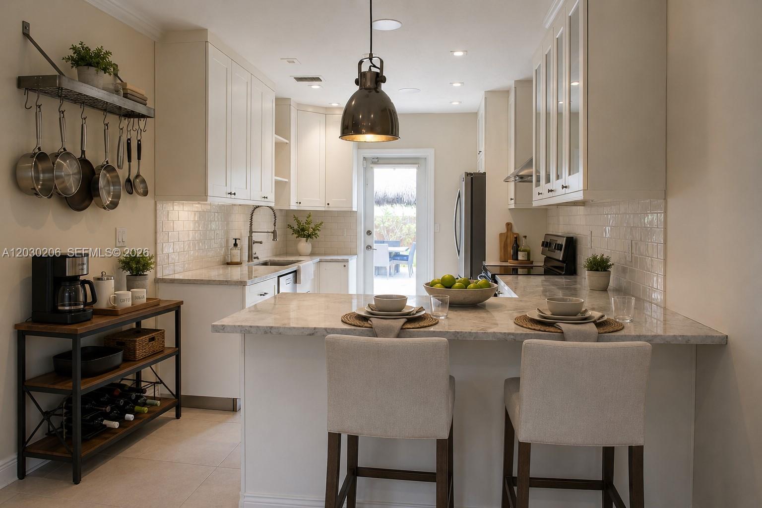 A kitchen features white cabinetry, marble countertops, a breakfast bar with two stools, and stainless appliances — 6530 SW 43rd St, Miami FL 33155, MIAMI, FL