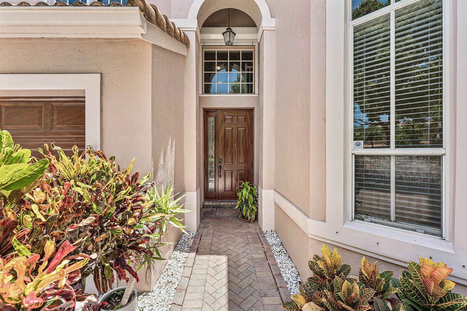 A brick walkway leads to a wooden front door under an arched entryway — 4858 S Classical Boulevard, Delray Beach FL 33445, DELRAY BEACH, FL