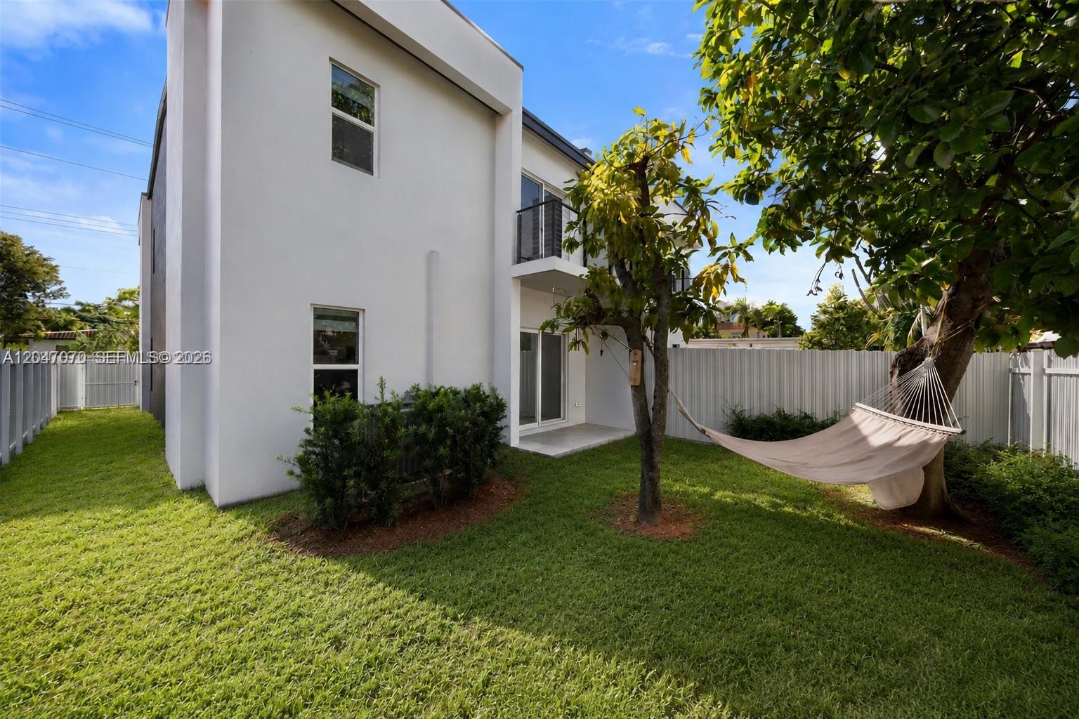 A white two-story house features a backyard with a hammock hanging from a tree — 3431 SW 16th Ter # 1, Miami FL 33145, MIAMI, FL
