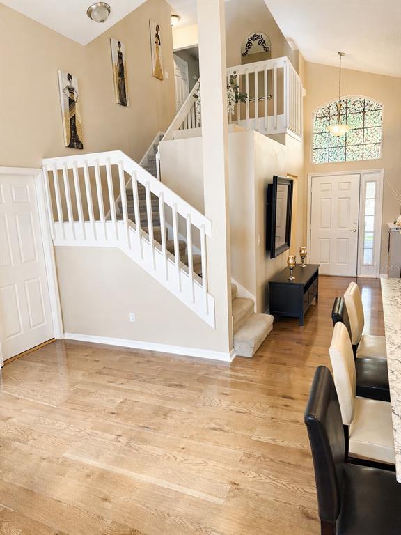 An interior view of a foyer with a staircase, hardwood floors, and a front door — 227 DILLON WAY, DAVENPORT, FL