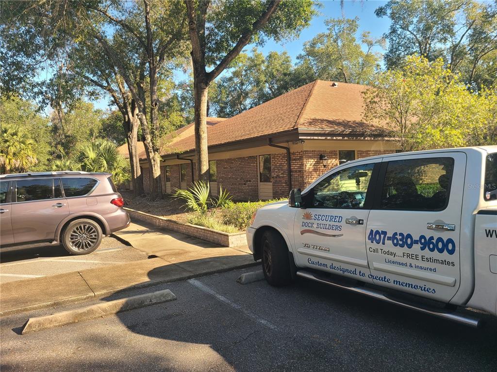 A white work truck is parked in front of a single-story brick office building — 483 MONTGOMERY PLACE, ALTAMONTE SPRINGS, FL