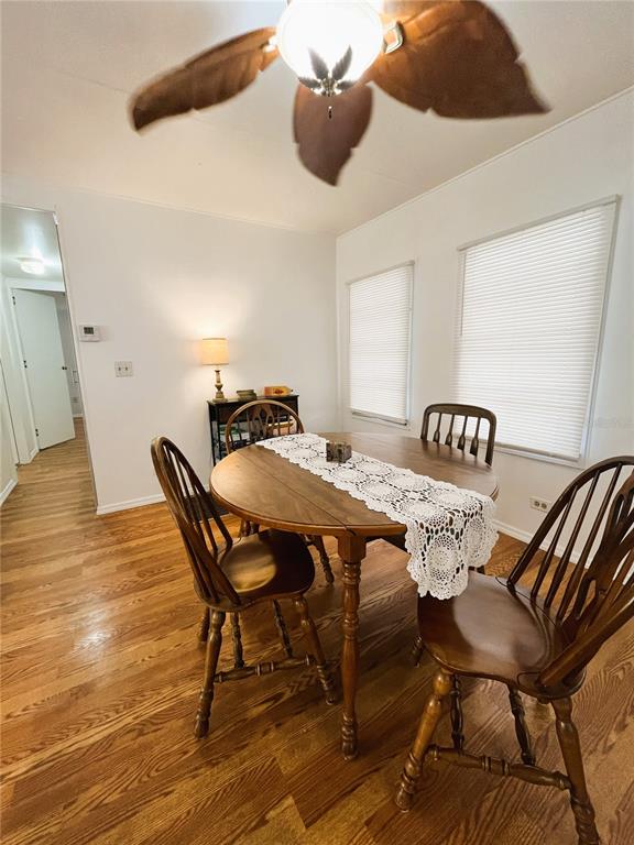 A dining room features a round wooden table, four chairs, and hardwood flooring — 6916 MARLIN LANE, BRADENTON, FL
