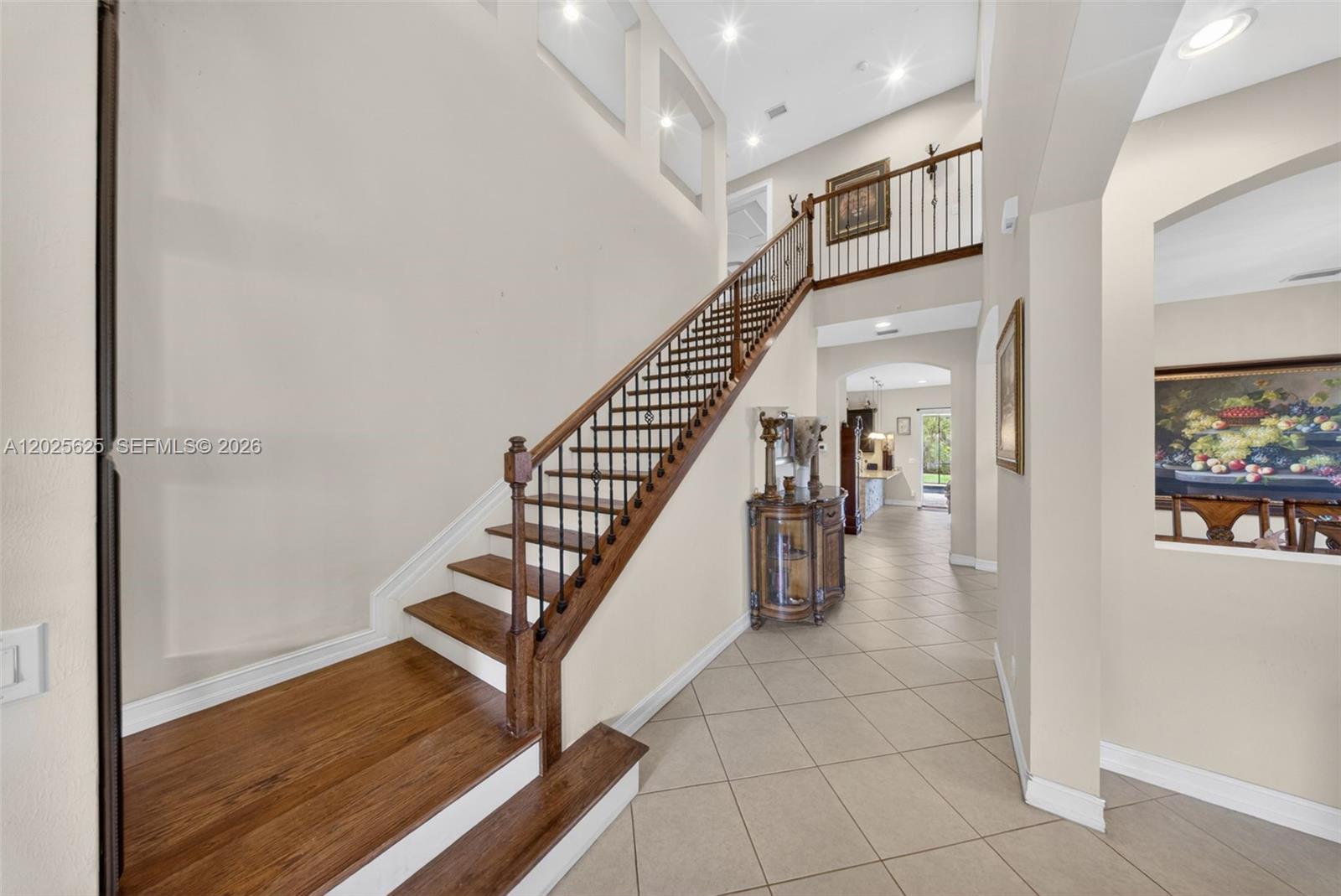 A staircase with wooden treads and a metal railing leads to a second-floor landing — NORTH FORT MYERS, FL