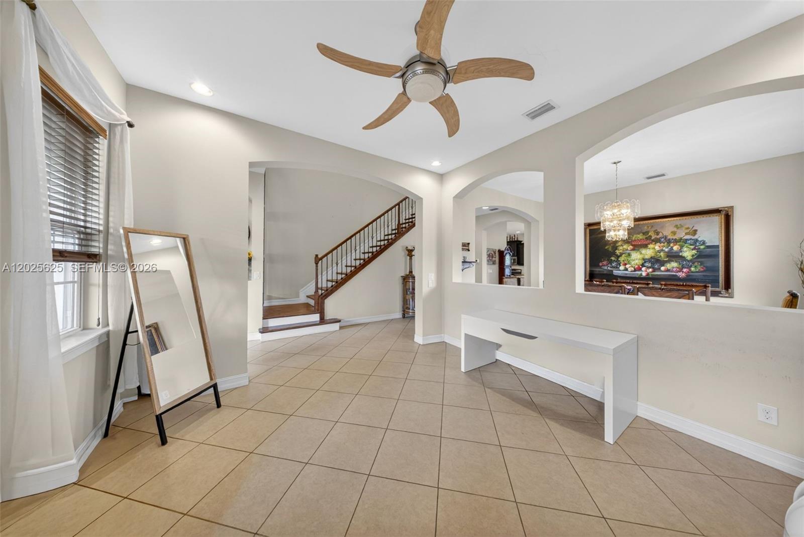 An entryway features tile flooring, a staircase, a white console table, and a floor mirror — NORTH FORT MYERS, FL