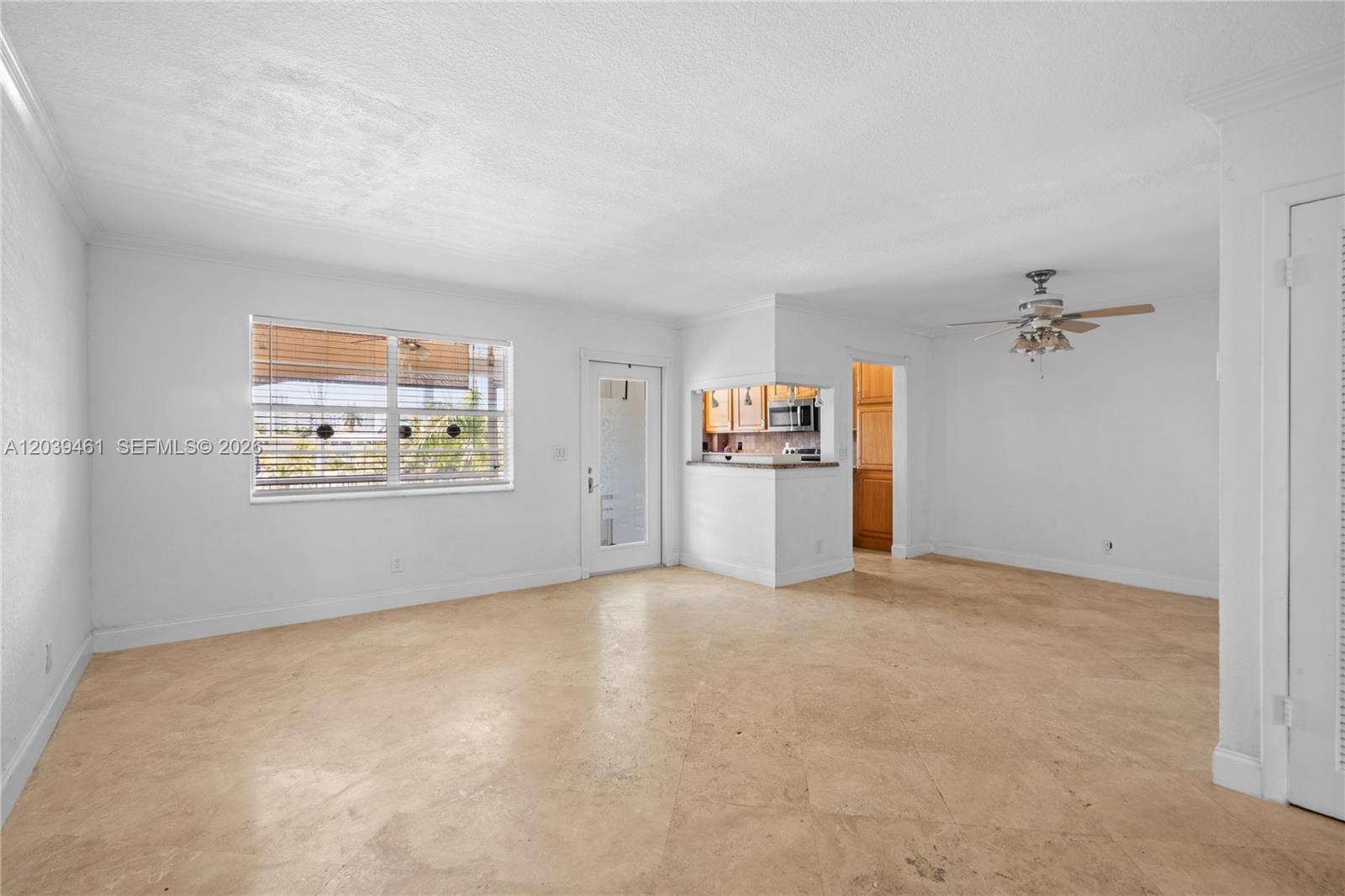 An empty living room features white walls, beige tile flooring, and a ceiling fan — 541 Blue Heron Dr # 308, Hallandale Beach FL 33009, HALLANDALE BEACH, FL