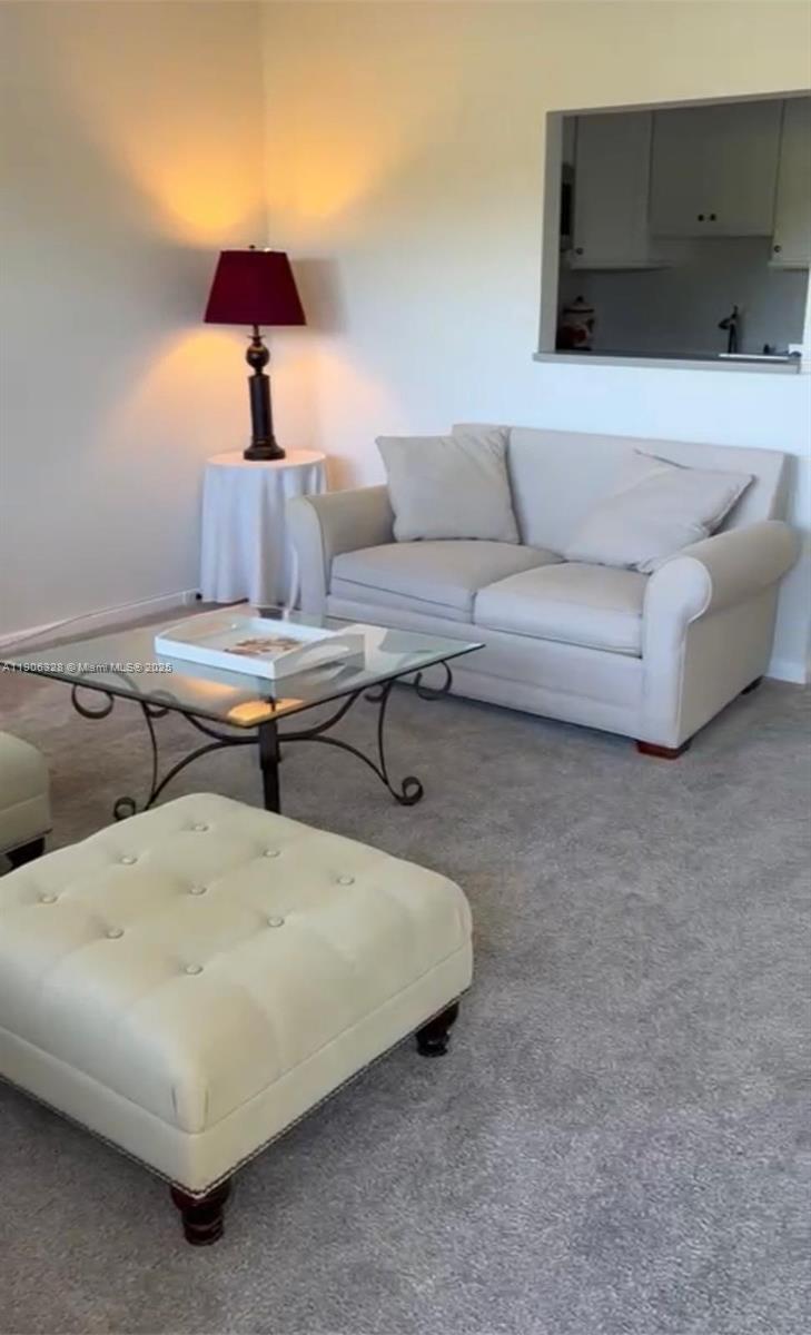 A living room features a light-colored sofa, a tufted ottoman, and a glass coffee table — 22 Brighton A # 22, Boca Raton FL 33434, BOCA RATON, FL