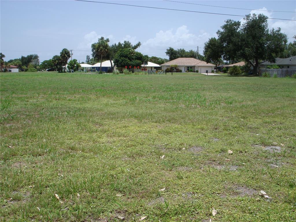 A large, grassy vacant lot sits in front of several suburban houses and trees — 2301 S TAMIAMI TRAIL, OSPREY, FL