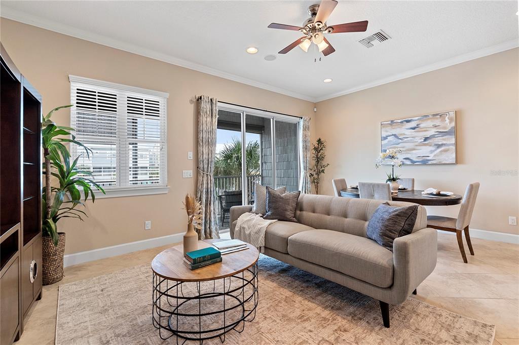 A living room features a gray sofa, a round coffee table, and a dining area — 6043 ANCHORAGE WAY S, ST PETERSBURG, FL