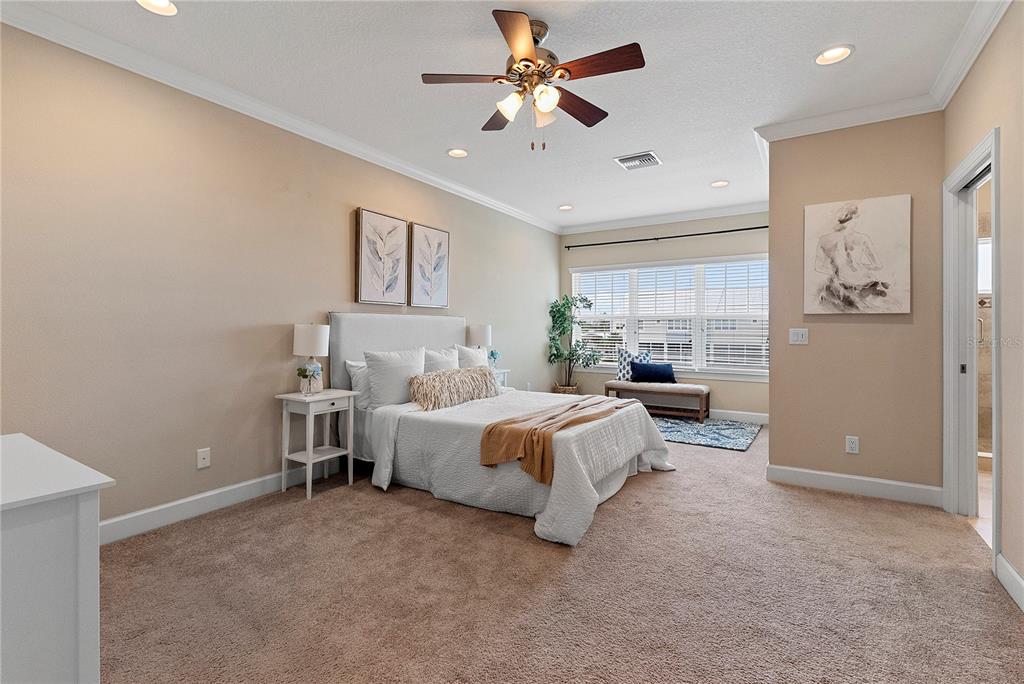 A bedroom features a bed, a ceiling fan, recessed lighting, and a doorway to a bathroom — 6043 ANCHORAGE WAY S, ST PETERSBURG, FL