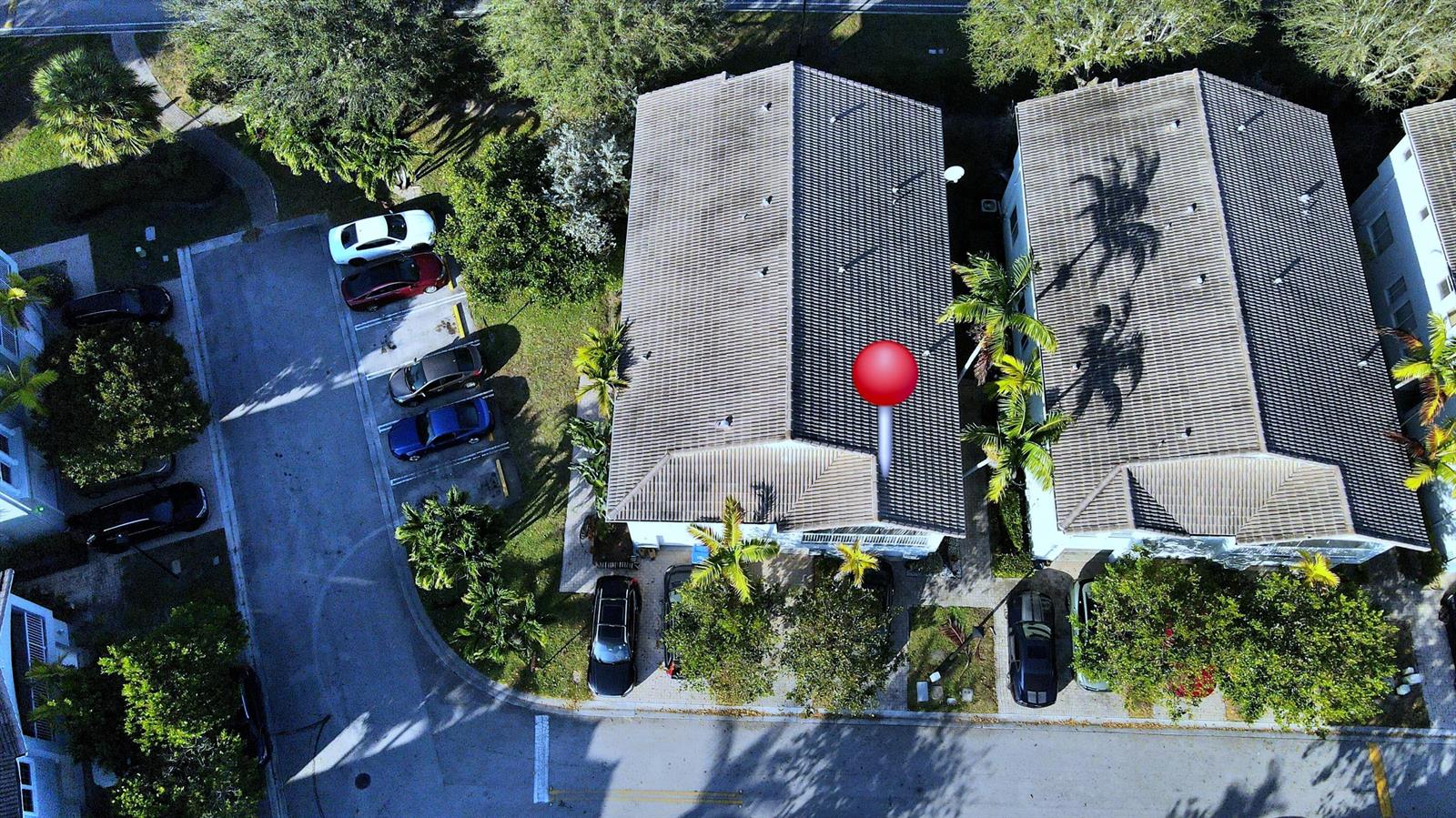 An aerial view shows two adjacent residential buildings with tiled roofs and nearby parking spaces — 3037 Laurel Ridge Circle, Riviera Beach FL 33404, RIVIERA BEACH, FL