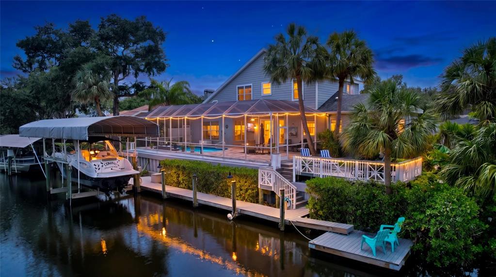A gray house with a paved driveway, a front porch, and large green trees — 360 46TH COURT E, BRADENTON, FL