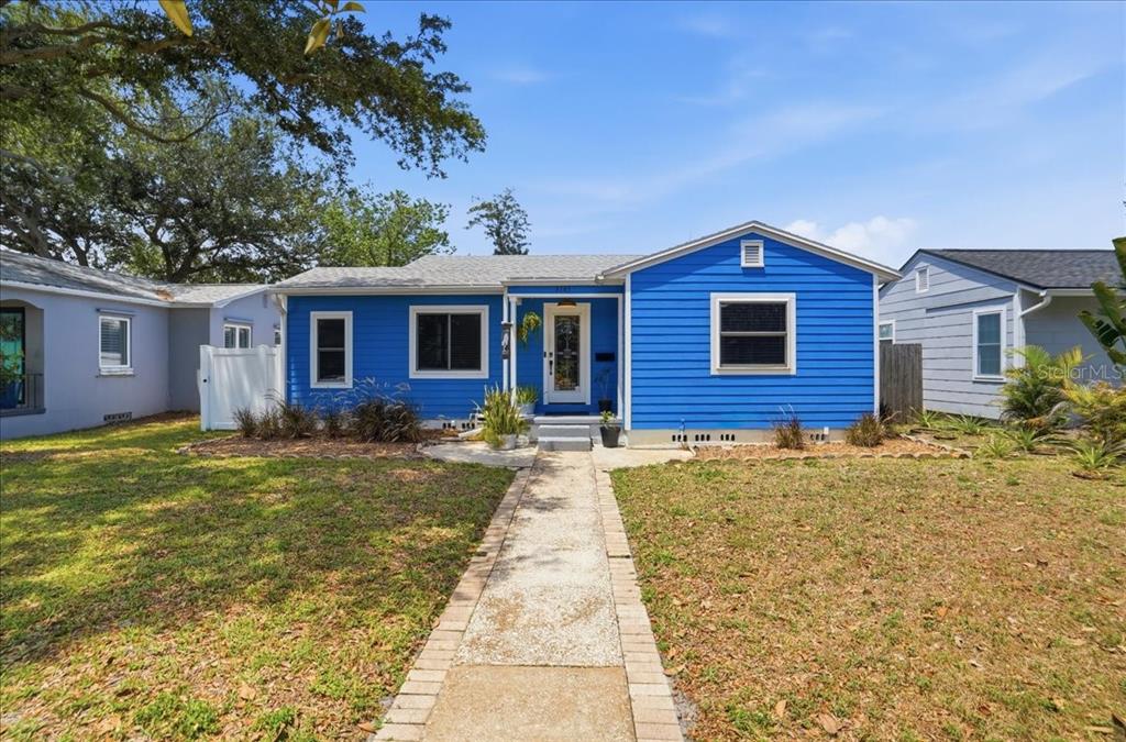 A bright blue, single-story house with a front walkway and a grassy yard — 3145 8TH AVENUE N, ST PETERSBURG, FL