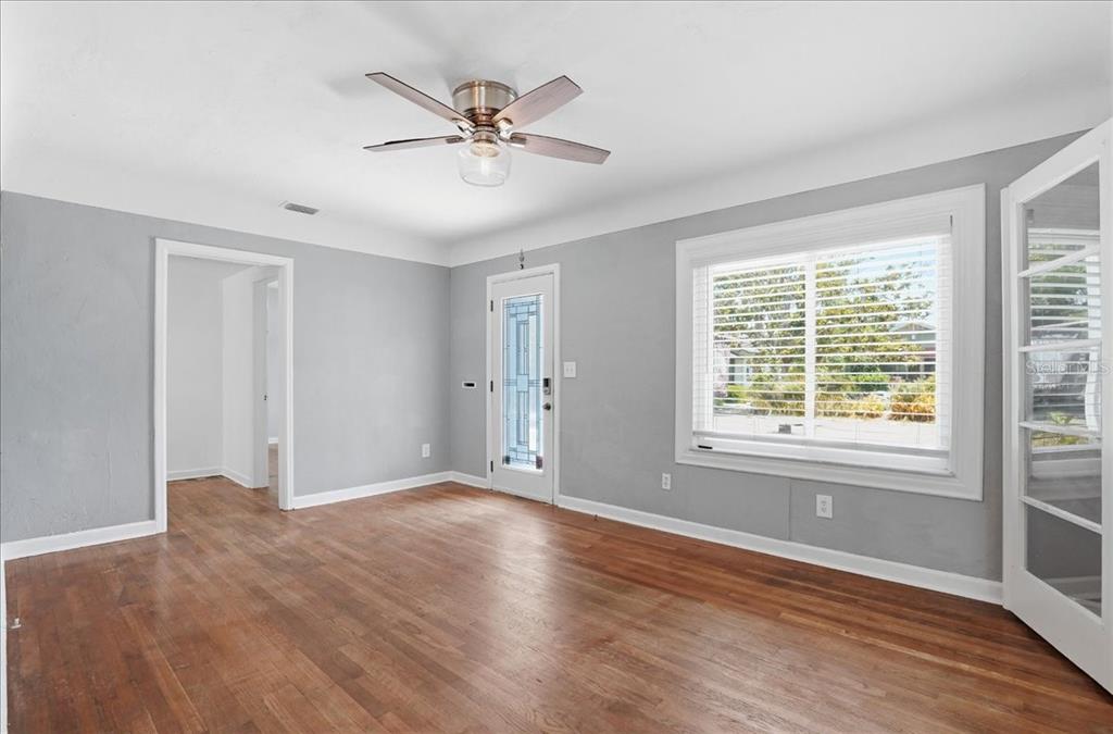 A living room with hardwood floors, a ceiling fan, and virtual staging furniture — 3145 8TH AVENUE N, ST PETERSBURG, FL
