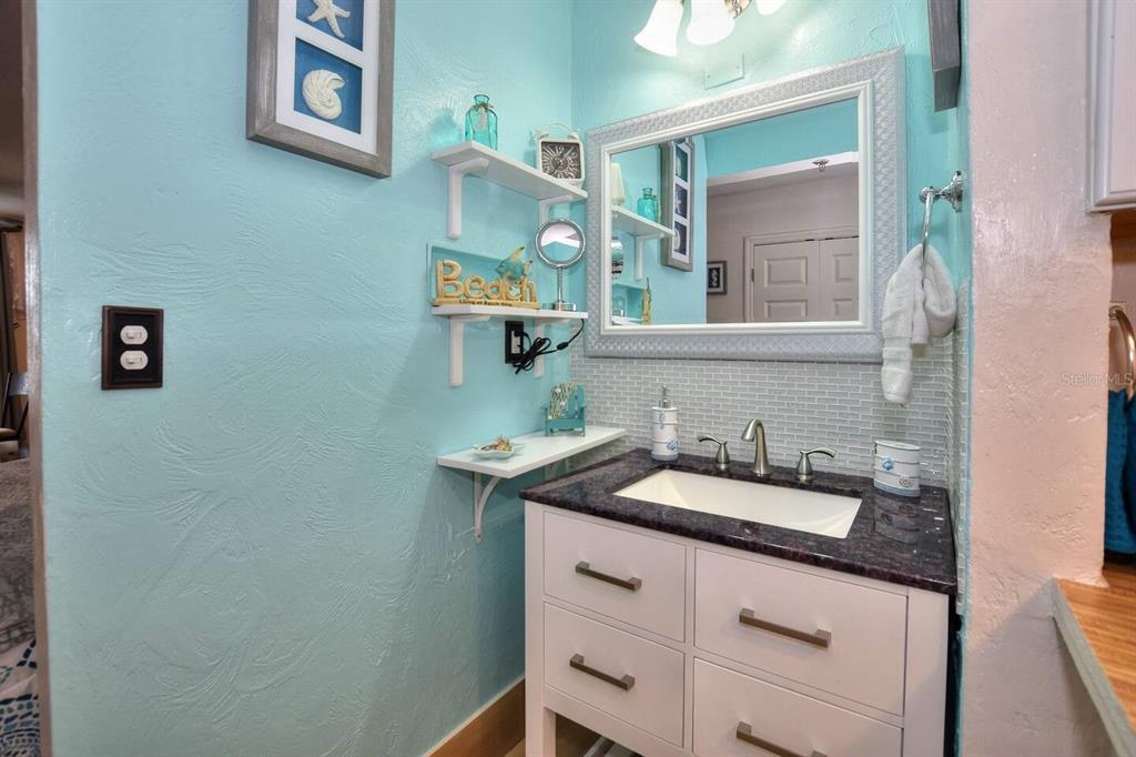 A bathroom features a white vanity with a dark countertop, a mirror, and blue walls — 313 S ATLANTIC AVENUE UNIT 2170, DAYTONA BEACH, FL