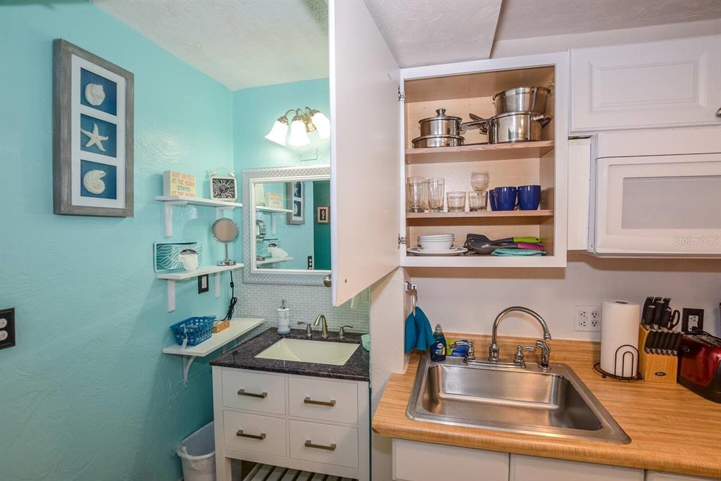 A small kitchen area features a sink, open cabinetry, and a vanity with a sink — 313 S ATLANTIC AVENUE UNIT 2170, DAYTONA BEACH, FL