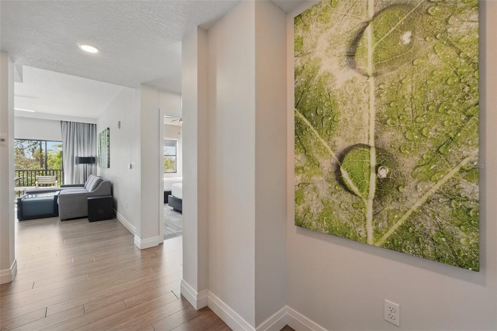 A hallway leads to a living area with a balcony and a bedroom beyond — 14501 GROVE RESORT AVENUE UNIT 2232, WINTER GARDEN, FL