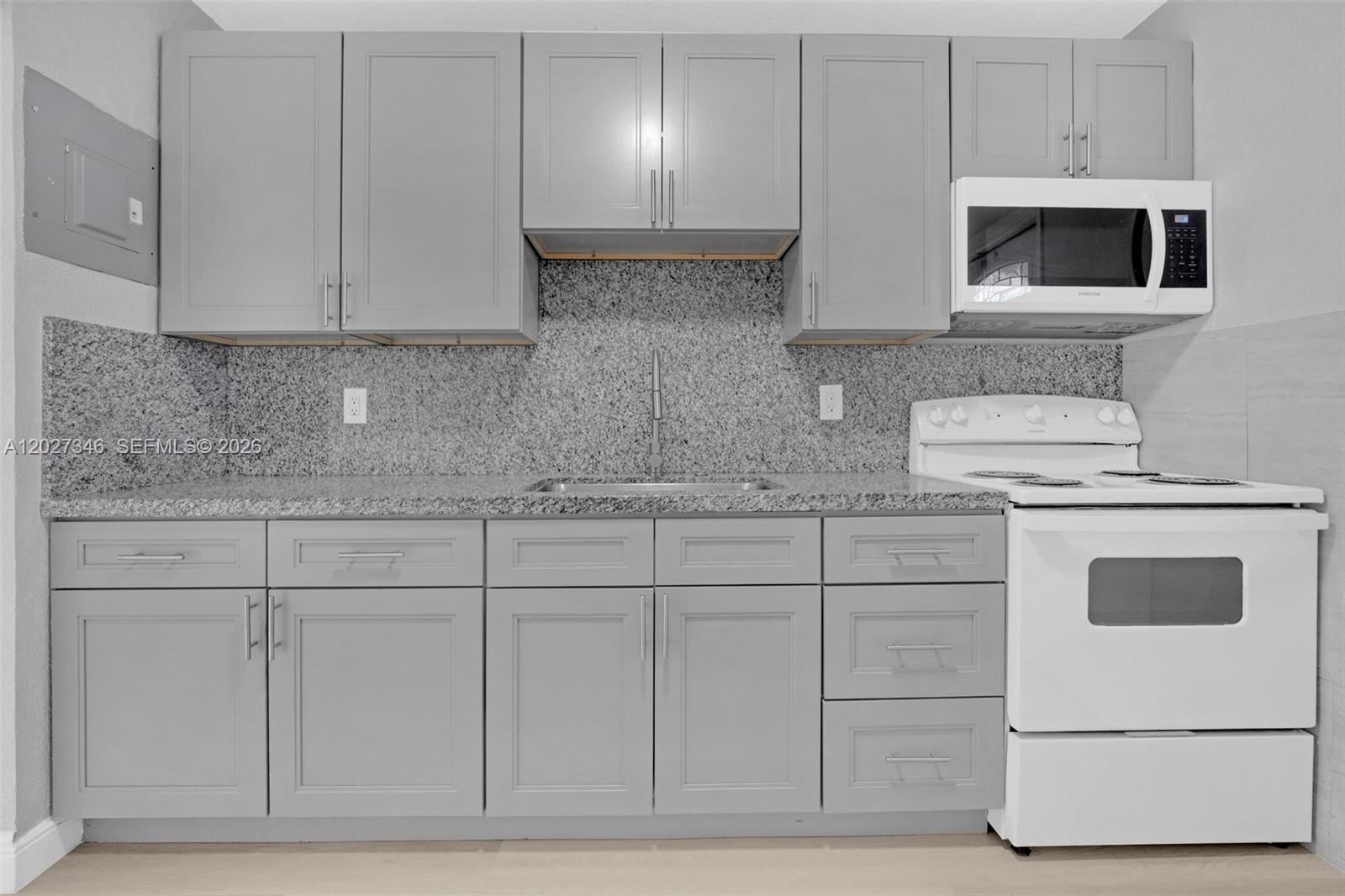 A kitchen features gray shaker-style cabinets, granite countertops, and white appliances — 369 Phippen Waiters Rd # 1, Dania Beach FL 33004, DANIA BEACH, FL