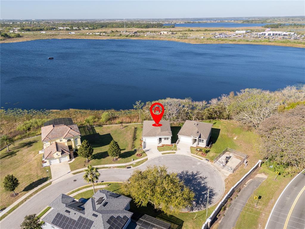 An aerial view shows a house with a red location pin situated near a lake — 356 CHEROKEE AVENUE, HAINES CITY, FL