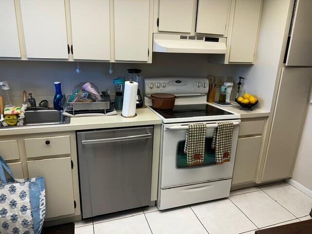 A kitchen features white cabinets, a stainless steel dishwasher, and a white electric range — 3186 Via Poinciana # 306, FL 33467, FL