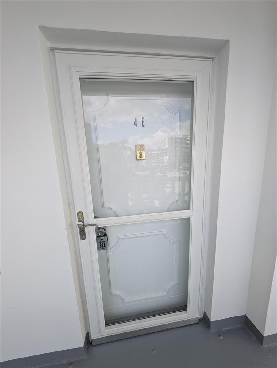 A white storm door with a keypad lock and the number 4E on the glass — 3209 S Ocean Drive # 4E, Hallandale Beach FL 33009, HALLANDALE BEACH, FL