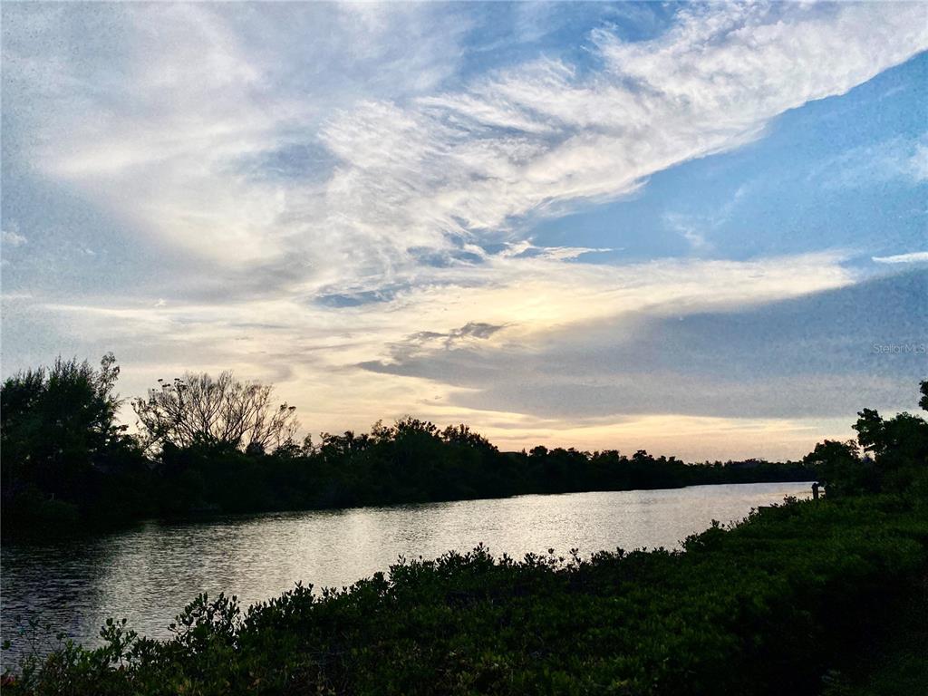 A view of a calm river at sunset with trees along the banks — 7820 MIDNIGHT PASS, SARASOTA, FL