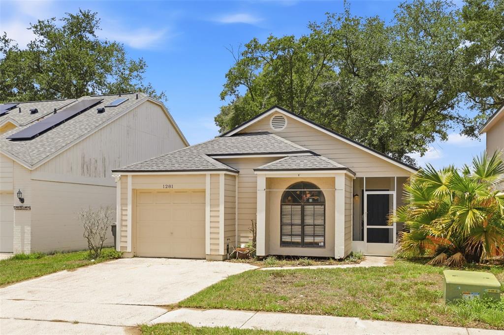 A single-story house with beige siding, a one-car garage, and a screened-in front entryway — 1281 CROSSFIELD DRIVE, APOPKA, FL