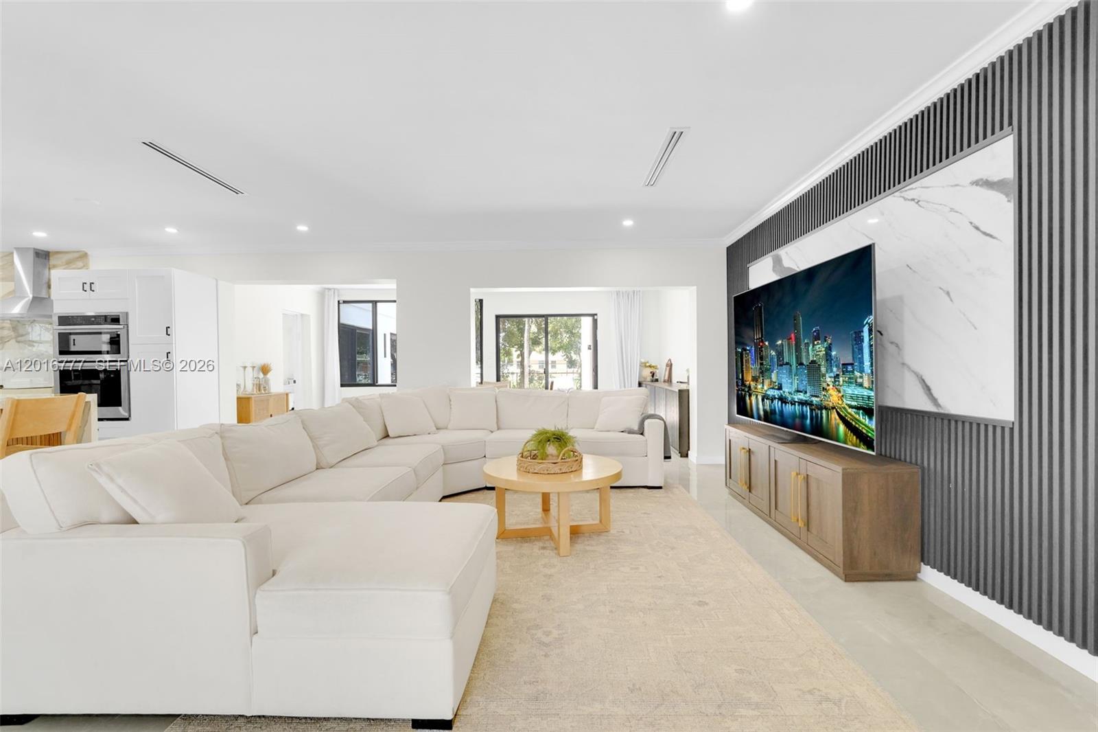 A living room features a large white sectional sofa, a round coffee table, and a television — 3411 Thomas St, Hollywood FL 33021, HOLLYWOOD, FL