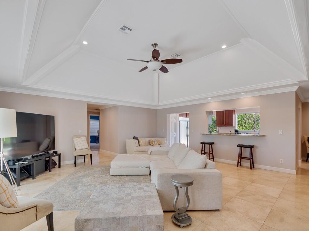 A spacious living room features a vaulted ceiling, tile flooring, and an open kitchen pass-through — 527 E Causeway Boulevard, Vero Beach FL 32963, VERO BEACH, FL