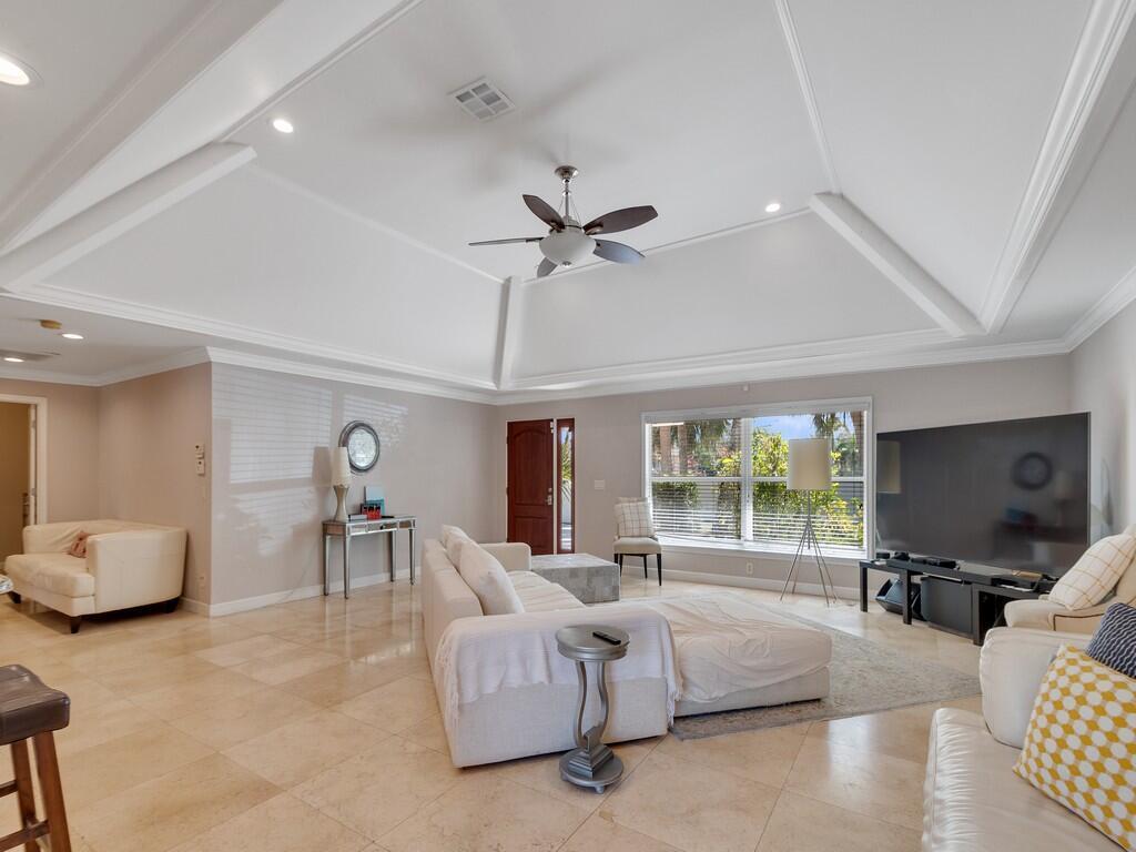 A spacious living room features a tray ceiling, tile flooring, and a large sectional sofa — 527 E Causeway Boulevard, Vero Beach FL 32963, VERO BEACH, FL