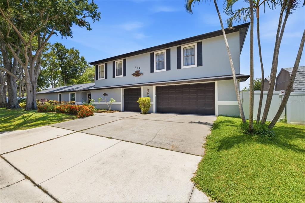 A two-story house with a gray exterior, dark shutters, and a multi-car garage — 176 MAPLE AVENUE, PALM HARBOR, FL