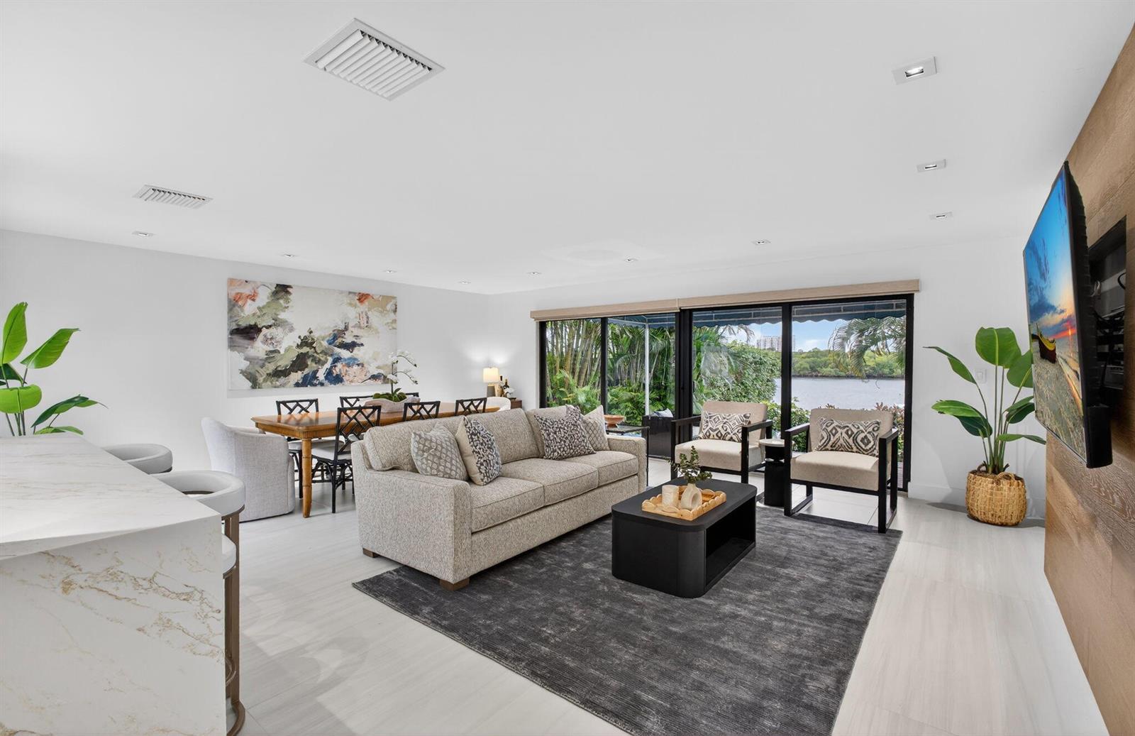 A bright living and dining area features a sofa, coffee table, and large sliding glass doors — 6550 N Ocean Boulevard # 1, Ocean Ridge FL 33435, OCEAN RIDGE, FL
