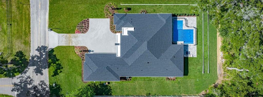 An aerial view shows a house with a dark roof, a swimming pool, and a driveway — 1680 SE 20TH AVENUE, OCALA, FL