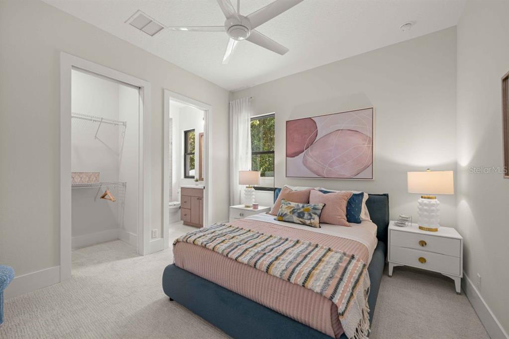 A bedroom features a blue upholstered bed, white nightstands, and an attached walk-in closet — 1680 SE 20TH AVENUE, OCALA, FL