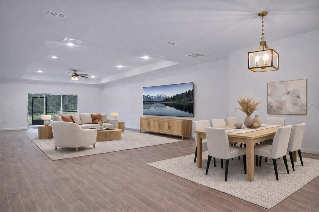 A virtually staged open-concept living and dining room with light wood floors and recessed lighting — 19426 SW 79TH STREET, DUNNELLON, FL