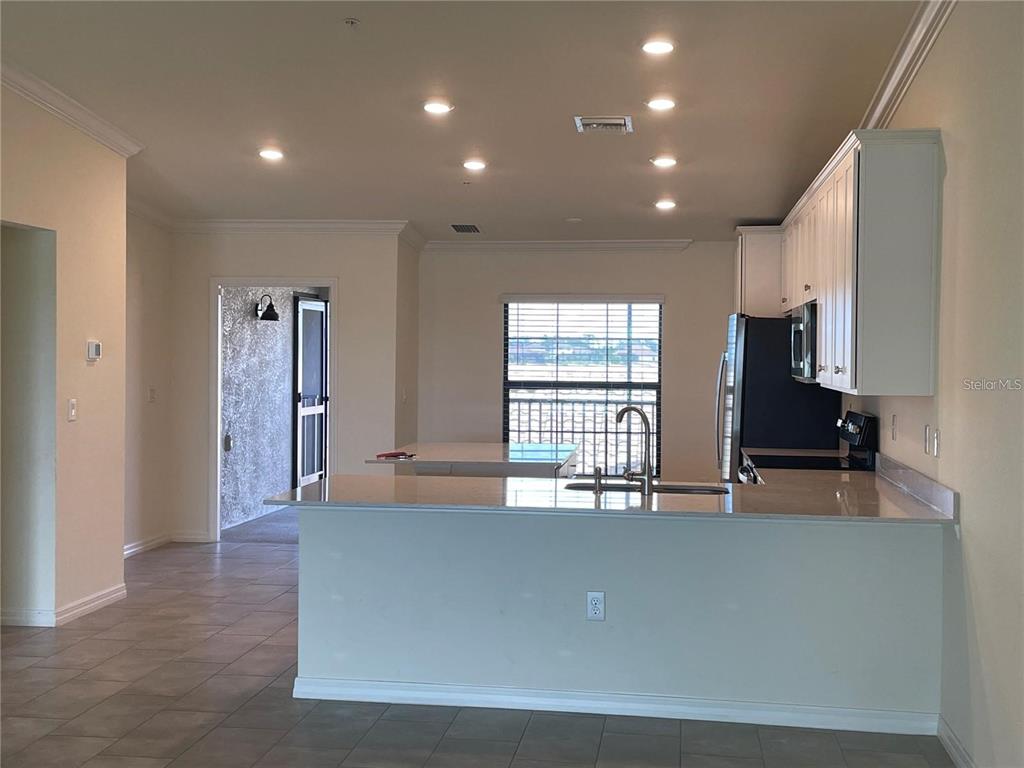 A kitchen with white cabinets, granite countertops, a breakfast bar, and recessed lighting — 5674 PALMER CIRCLE UNIT 206, BRADENTON, FL