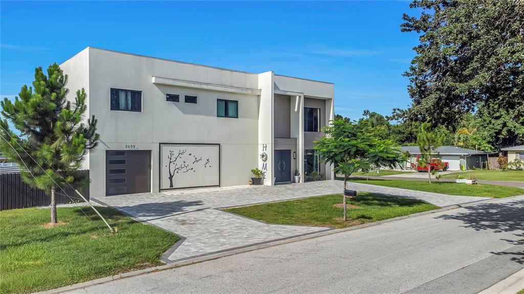 A modern two-story house with a paved driveway, a garage, and a decorative wall panel — 2635 WOODRING DR, CLEARWATER, FL