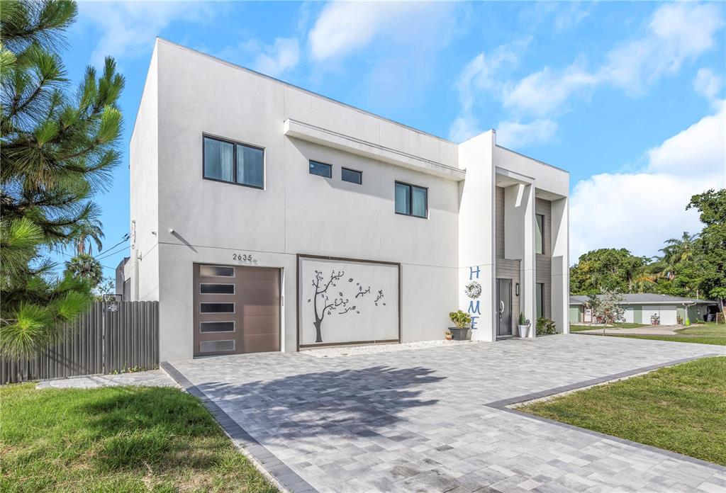A modern two-story house with a white exterior, a paved driveway, and a garage — 2635 WOODRING DR, CLEARWATER, FL