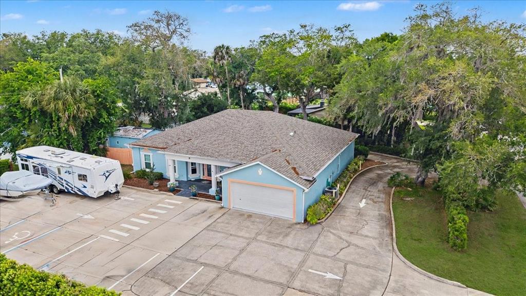 An aerial view of a light blue house with a large concrete driveway and RV — 1830 ORANGE TREE DRIVE, EDGEWATER, FL