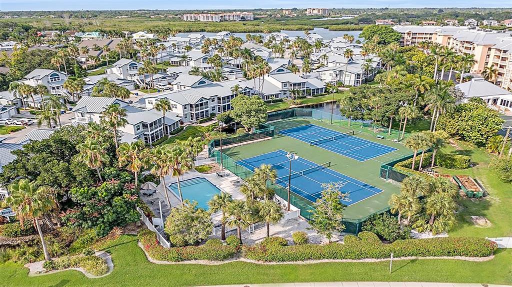 An aerial view shows a residential complex with two tennis courts and a swimming pool — 1360 SIESTA BAYSIDE DRIVE UNIT 1360-D, SARASOTA, FL
