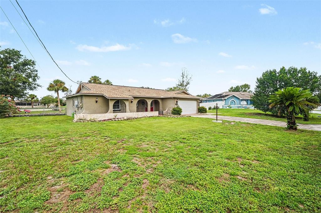 A single-story house with a tan stucco exterior, arched entryway, and a two-car garage — 179 HAGUE COURT UNIT 5, SPRING HILL, FL