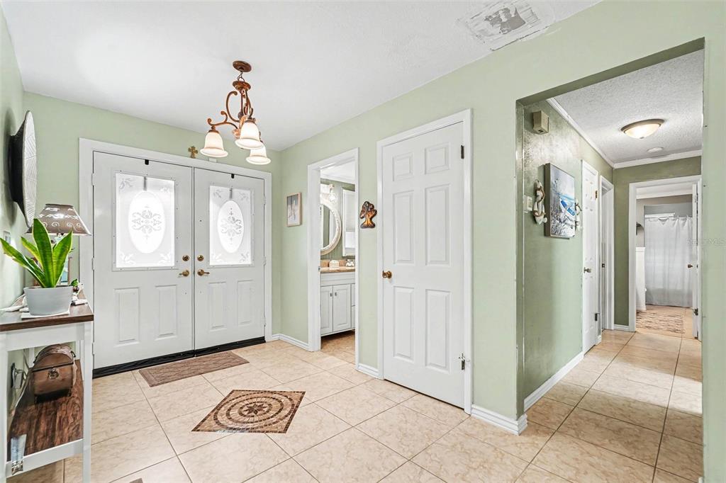 A tiled entryway features double front doors, light green walls, and several interior doorways — 179 HAGUE COURT UNIT 5, SPRING HILL, FL