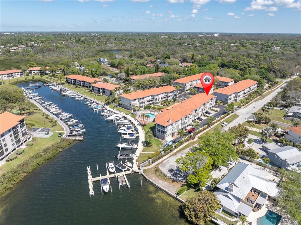 An aerial view shows a waterfront condominium complex with a marina and a swimming pool — 1501 WHARFSIDE DRIVE, TARPON SPRINGS, FL