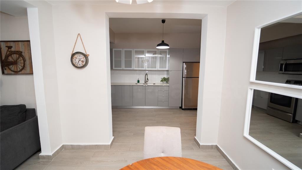 A view from a dining area looking into a modern kitchen with gray cabinetry — 2058 ESPAÑA STREET, SAN JUAN, PR