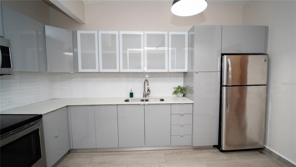 A kitchen features gray flat-panel cabinets, stainless steel appliances, and a white tiled backsplash — 2058 ESPAÑA STREET, SAN JUAN, PR